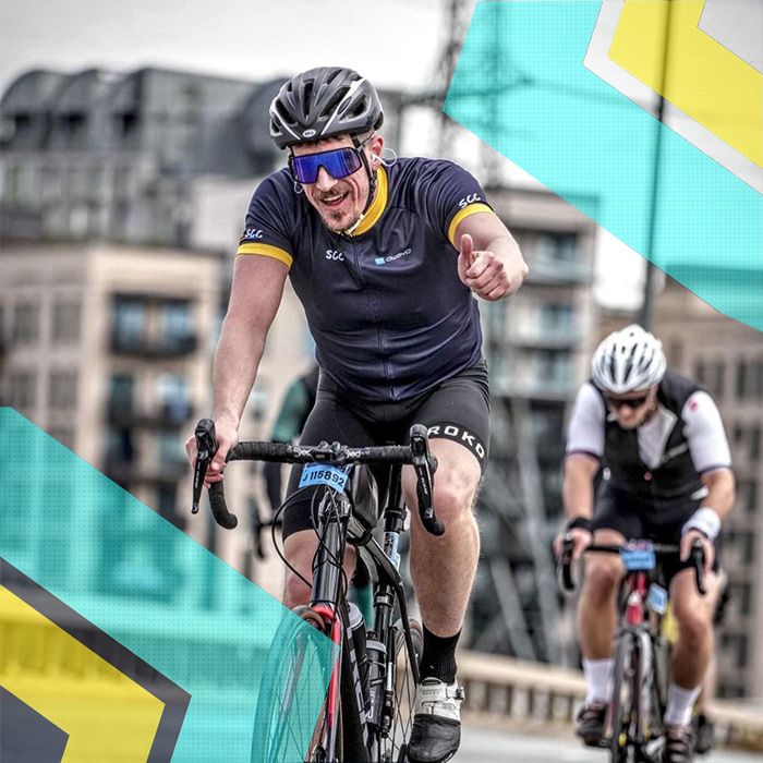 A member of Surrey Cycling Club rides a bike on a bridge.