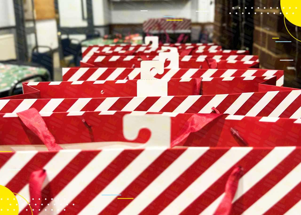 A line of red and white striped gift bags on a table.