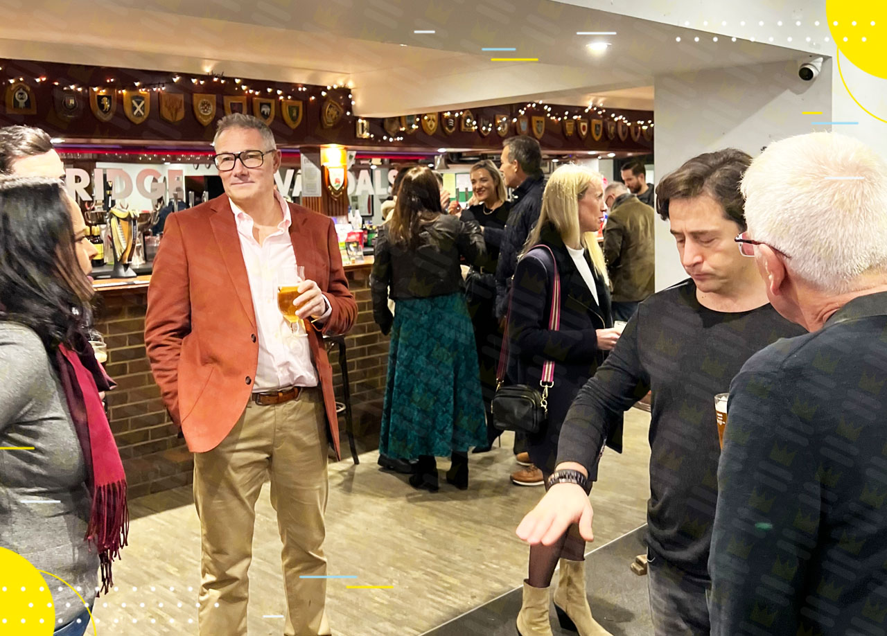 A group of people talking at a bar.