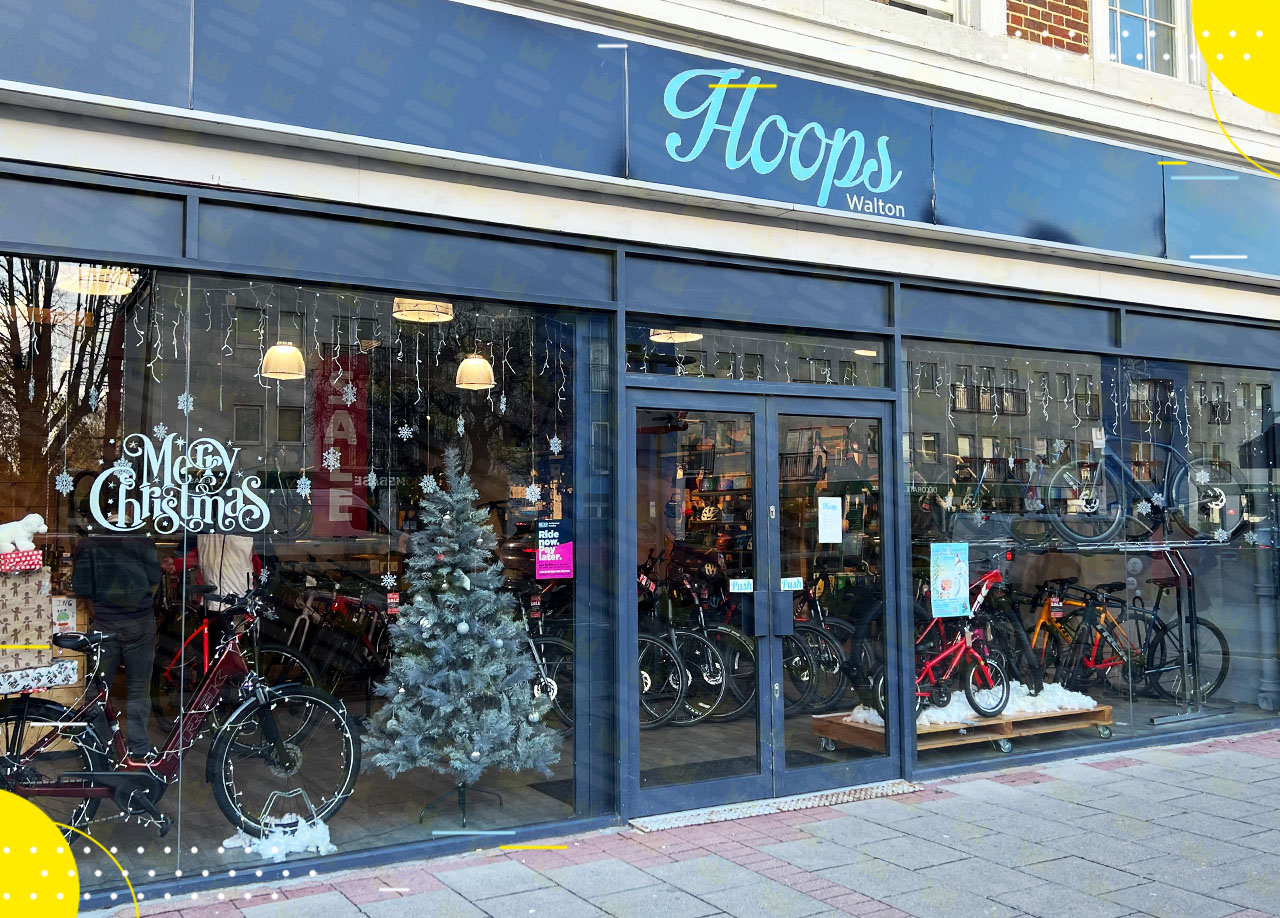 A bicycle shop with a christmas tree in front of it.