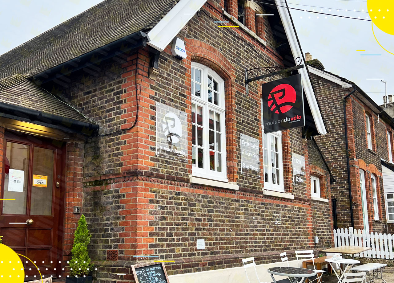 A brick building with tables and chairs outside.