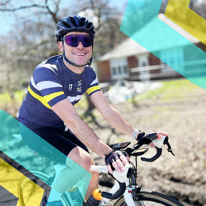 A man on a bike smiling in front of a house, representing the Surrey Cycling Club.