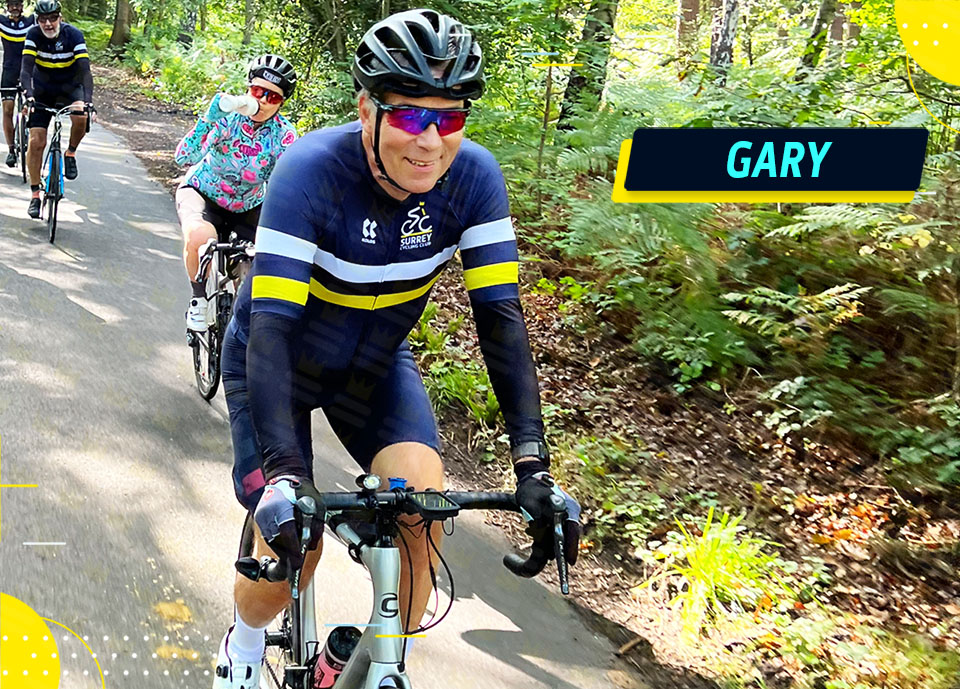 A group of cyclists riding down a path in the woods.